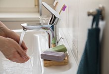 Frau wäscht sich die Hände unter warmen Wasser - Christin Klose/dpa-tmn