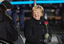 Rote Rose f&uuml;r Merkel - Foto: Michael Kappeler/dpa