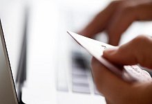 Jemand gibt am Notebook seine Kreditkartendaten ein. - Foto: Franziska Gabbert/dpa-tmn