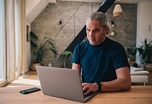 Mann arbeitet an einem Laptop - Zacharie Scheurer/dpa-tmn