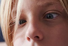 Ein Kind testet, ob es absichtlich schielen kann - Annette Riedl/dpa/dpa-tmn