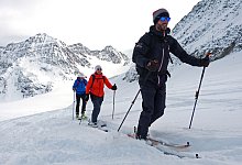 Personen mit Skiern im Schnee - Florian Sanktjohanser/dpa-tmn