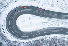 Autos fahren bei winterlichem Wetter eine Serpentine entlang - Sebastian Kahnert/dpa/dpa-tmn