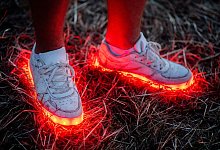 Ein Mann trägt ein paar rotleuchtende Schuhe - Hauke-Christian Dittrich/dpa/dpa-tmn