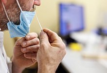 Ein Mann testet sich am Arbeitsplatz. Unternehmen sollen ab Herbst nun doch nicht verpflichtet werden, ihren Besch&auml;ftigten erneut Homeoffice und Corona-Tests anzubieten. - Matthias Balk/dpa