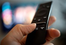 Ein Mann h&auml;lt eine Fernbedienung mit der Aufschrift Amazon Prime - Zacharie Scheurer/dpa-tmn