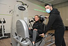 Anthony Watts mit seiner Auszubildenden Lea Wobig an der Beinpresse. Im Studio werden Stellen f&uuml;r Schnelltests weitergegeben. - Karin Prignitz