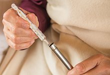 Frau h&auml;lt ein Fieberthermometer mit Quecksilber in den H&auml;nden - Christin Klose/dpa-tmn