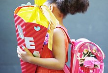 Ein Kind hält bei der Einschulung eine Schultüte im Arm - Oliver Berg/dpa/dpa-tmn