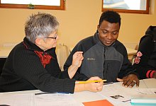 Noch ganz am Anfang: Martina Rudolphi, die zur Kontaktgruppe geh&ouml;rt, hilft Draman Sanouno seine ersten deutschen Worte aus Papier zu bringen. - Freya K&ouml;hring