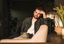 Mann sitzt gedankenvoll auf einer Couch - Uwe Umst&auml;tter/Westend61/dpa-tmn