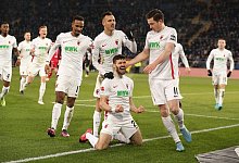 Der Augsburger Daniel Caligiuri (M. unten) l&auml;sst sich feiern. - Friso Gentsch/dpa