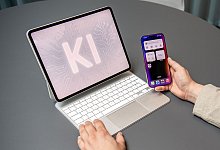 Ein Mann nutzt einen KI-Assistenten auf einem iPad und iPhone - Nico Tapia/dpa-tmn