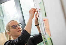 Junge Frau arbeitet an einem Flipchart - Christin Klose/dpa-tmn