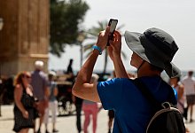 Ein Tourist fotografiert mit seinem Smartphone - Clara Margais/dpa/dpa-tmn