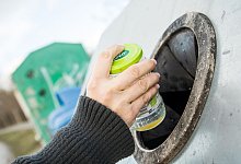 Hand h&auml;lt Glas mit Deckel am Container - Christin Klose/dpa-tmn