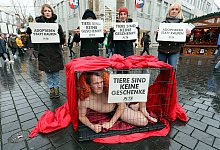 Rabea (v. l.), Anne, Anne-Sophie und Elisa unterst&uuml;tzen Jens Vogt (im K&auml;fig) beim Protest gegen das Leid der Tiere als Weihnachtsgeschenke. - Wolfgang Rudolf