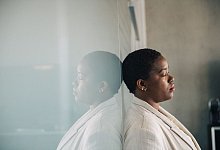 Eine junge Frau lehnt nachdenklich an einer Glaswand - Zacharie Scheurer/dpa-tmn