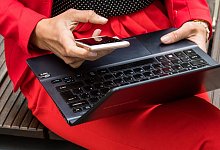 Eine Person mit Notebook und Smartphone in der Hand - Christin Klose/dpa-tmn