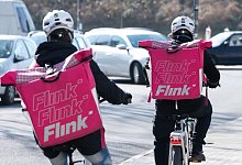 Zwei Fahrradkuriere mit Rucksäcken des Lebensmittel-Lieferdienstes Flink. - Sebastian Kahnert/dpa-Zentralbild/dpa
