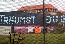 Der Schriftzug „Träumst Du?“ an einem Zaun. - Julian Stratenschulte/dpa/dpa-tmn