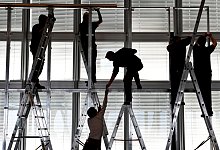 Silhouetten von Arbeitern, die eine Bühne abbauen - Arne Dedert/dpa/dpa-tmn