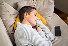 Eine Frau schläft auf einem Sofa - Christin Klose/dpa-tmn