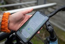 Eine Teilnehmerin hält ein Smartphone mit Anweisungen für das Outdoor-Spiel in die Kamera. - Thomas Banneyer/dpa