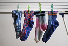 Socken auf einem Wäscheständer - Robert Michael/dpa