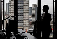 Frau steht an ihrem Arbeitsplatz am Fenster - Hannes P Albert/dpa/dpa-tmn