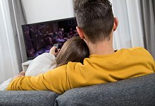 Ein Paar sitzt auf einer Couch vor dem Fernseher. - Christin Klose/dpa-tmn
