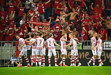 Vor den mitgereisten Fans feiern die Spieler des 1. FC K&ouml;ln das 2:0 beim Feh&eacute;rv&aacute;r FC. - Marton Monus/dpa