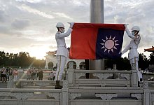Zwei Soldaten falten die Nationalflagge w&auml;hrend der t&auml;glichen Flaggenzeremonie auf dem Freiheitsplatz der Chiang-Kai-shek-Gedenkhalle in Taipeh. - Chiang Ying-Ying/AP/dpa
