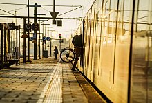Ein Bahnreisender hebt sein Fahrrad in eine S-Bahn - Andreas Arnold/dpa/dpa-tmn