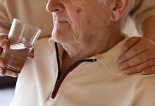 Eine Frau hilft einem Mann beim Trinken - Mascha Brichta/dpa Themendienst/dpa-tmn