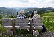 Zwei &auml;ltere M&auml;nner sitzen auf einer Bank - Patrick Seeger/dpa/dpa-tmn