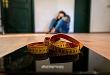 Maßband liegt auf einer Waage - Pia Bayer/dpa/dpa-tmn