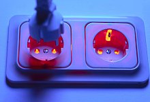 Droht im Winter die &Uuml;berlastung des Stromnetzes durch den Anschlu&szlig; von zu vielen Heizl&uuml;ftern? Rot leuchtende Steckdose m - IMAGO/Kosecki