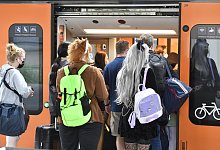 Bahnfahrer drängen sich am Sonntag am Eingang eines Regionalzuges am Deuter Bahnhof. Durch das 9-Euro-Ticket verzeichnet die Deutsche Bahn mehr ausgelastete Züge an Pfingsten. - Roberto Pfeil/dpa