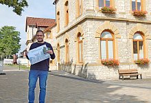 Patrick Piecha mit dem Kalender, f&uuml;r die er w&auml;hrend der vergangenen 18 Monate Oerlinghausen fotografisch erkundet hat. - Gunter Held
