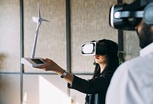 Businesswoman with VR glasses examining wind turbine model by colleague at office model released, Symbolfoto property re - IMAGO/Westend61