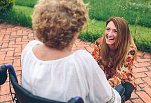 Young woman caring elderly woman in a wheelchair - David Pereiras