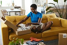 Happy woman unboxing packages at home - picture alliance / Westend61