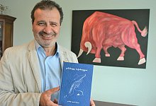 Jimsher Bedianashvili mit seinem neuesten Gedichtband. Dazu inspiriert worden ist er vom Bild seiner Tochter Natia, auf dem Stier Ciqara aus einem der bekanntesten georgischen M&auml;rchen zu sehen ist. - Karin Prignitz