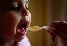 Kind schluckt Medizin - picture alliance