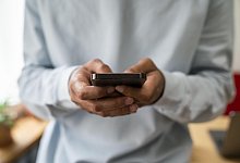 Hands of man text messaging through smart phone at home - picture alliance / Westend61