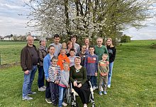 Johann und Helene Wins (links) unterstützen die Familie Korchak. Dazu gehören die Eltern Ludmilla und Igor sowie Großmutter Alla im Rollstuhl und die Kinder Alexander, Ernest, Victoria, Julia, Tatjana, David, Vladislaw, Daniel, Anna, Nicol und Yelisei. - Dirk Windmöller