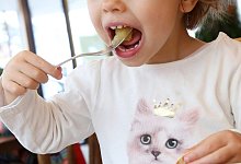 Ein Kind isst Apfelmus - Foto: Bodo Marks/dpa-tmn