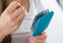 Eine Person hält eine Haarbürste in der Hand - Christin Klose/dpa-tmn