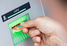 Ein Mann hebt am Automaten Geld ab - Fabian Sommer/dpa